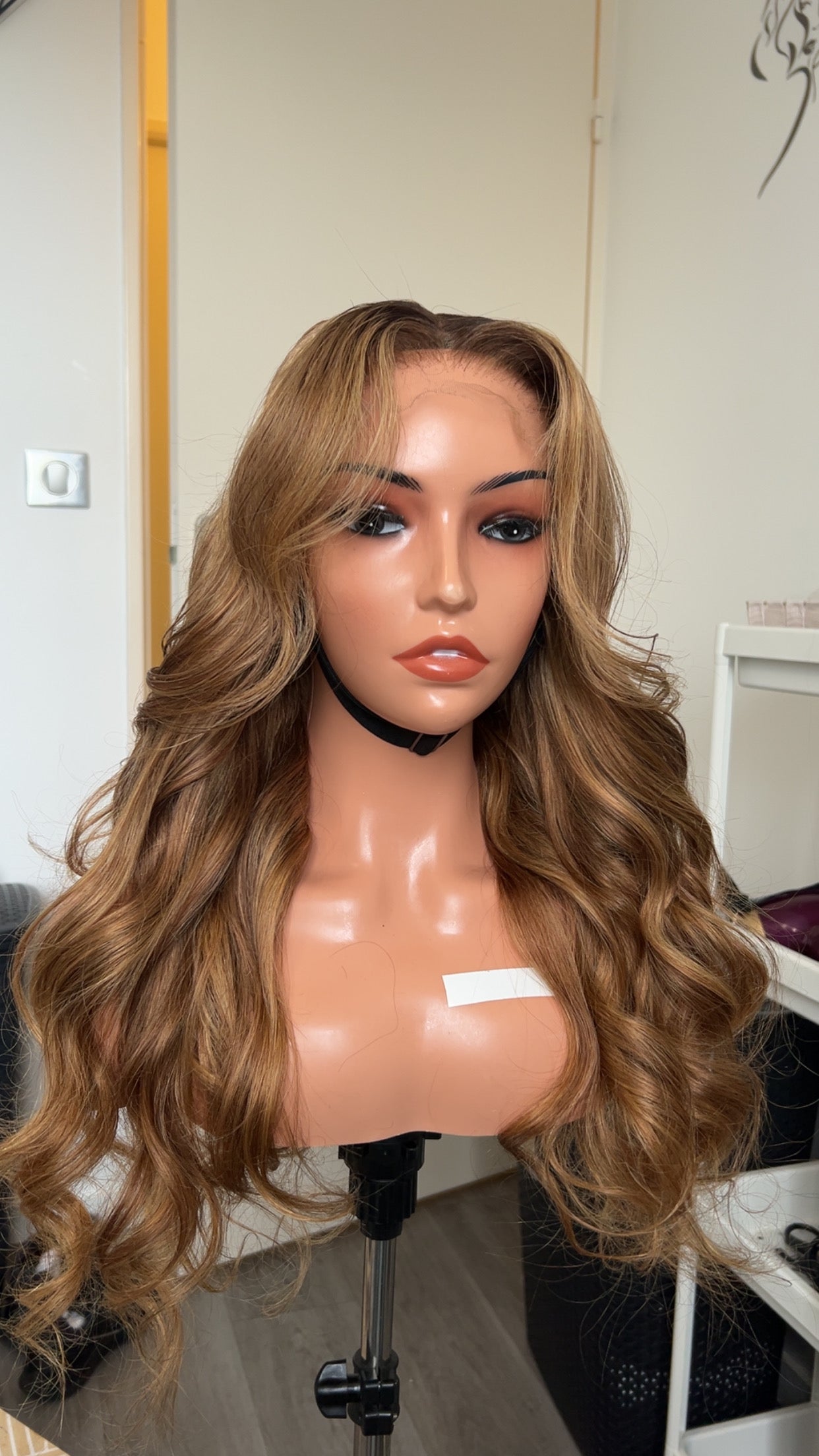 Perruque ondulée cheveux naturels - Lumière, avec des ondulations fluides et une couleur miel chaleureuse, sur un mannequin. Produit haut de gamme pour un style élégant et naturel.