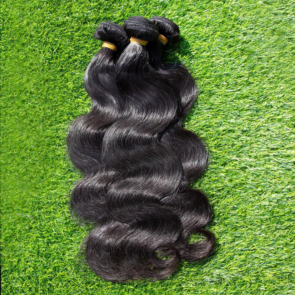 Tissage vierge Sonia Luxe Hair - Body Wave Bundle, avec des ondulations naturelles et une couleur noire profonde, présenté en trois mèches sur fond d'herbe. Produit haut de gamme pour un style élégant et authentique.